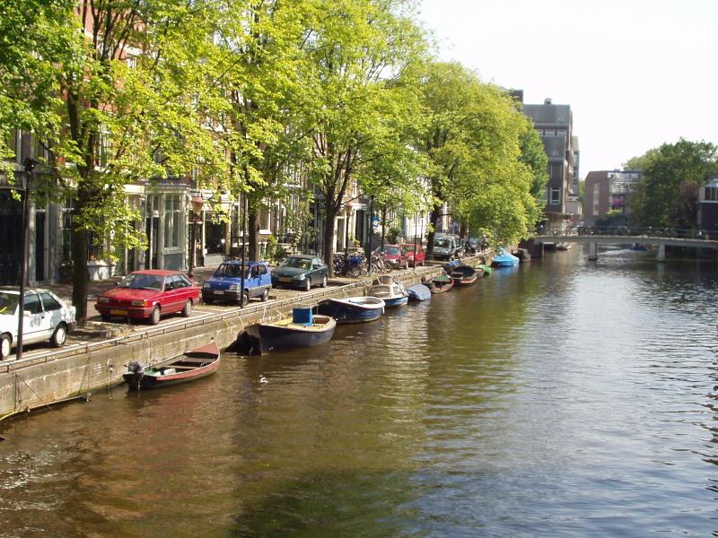 Casas, carros, bicis, rboles y botes en unos de los canales..